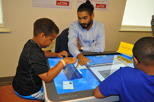 Man helping young boy use Activtable